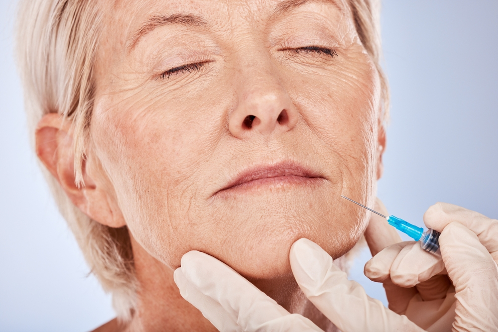 Femme mûre en train de se faire des injections d'acide hyaluronique